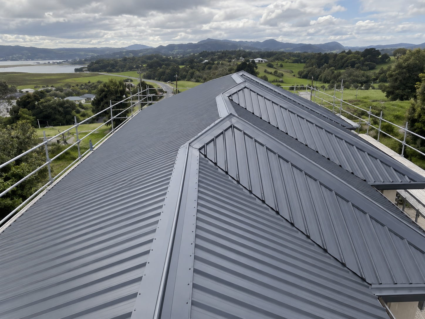 Aerial view of a long-run Colorsteel roof overlooking Whangarei Harbour